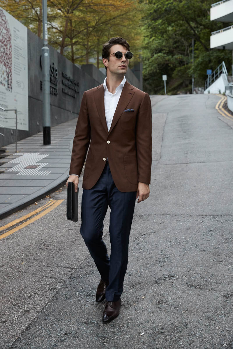 Man model in brown jacket aqua shirt and blue trousers at white brick wall  Stock Photo  Adobe Stock